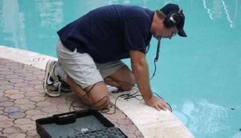 Pool expert performing diagnostics on an in-ground pool